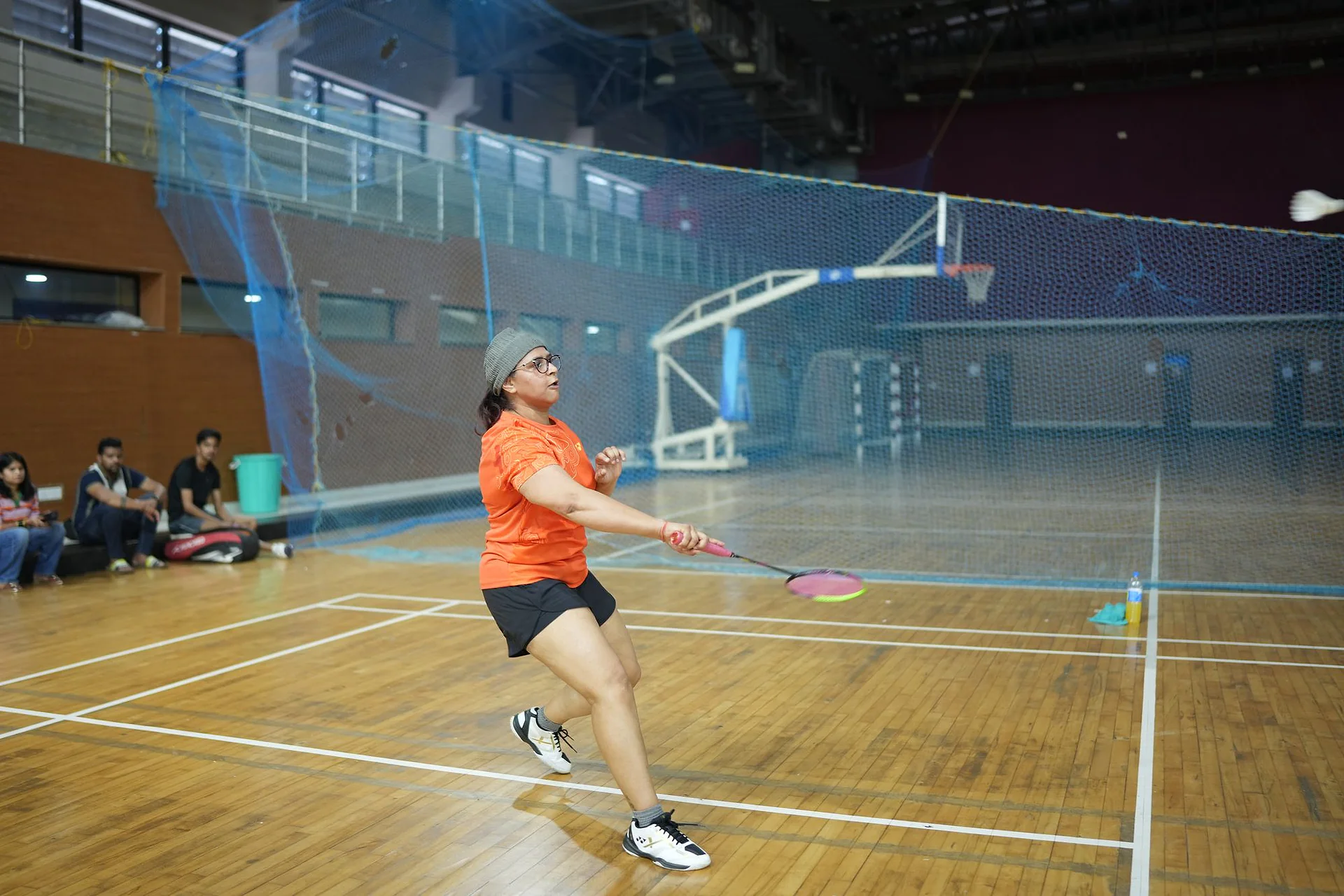 A player in orange returning a shot