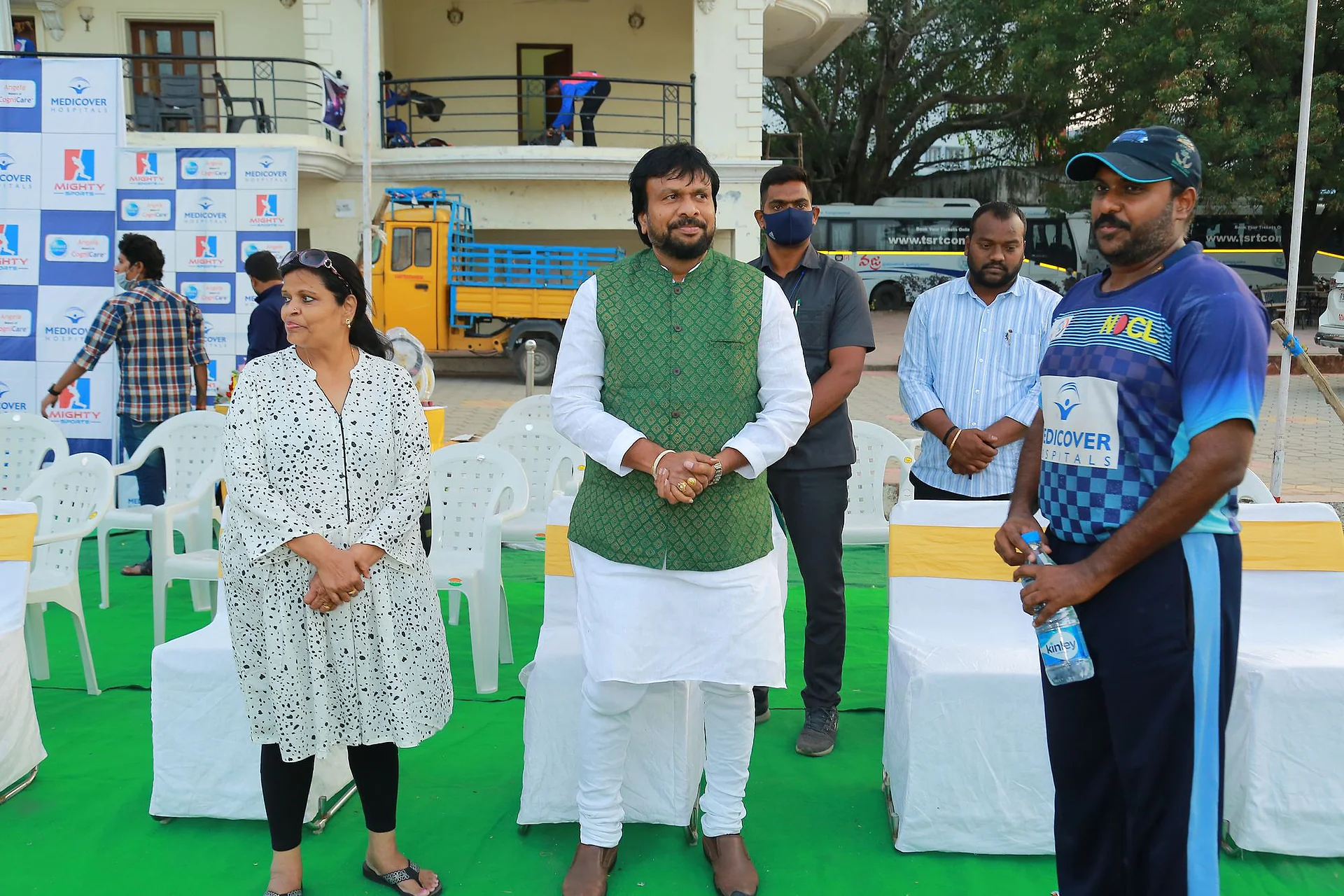 Guests and a player on the green carpet in front of the National Doctors Cricket League backdrop